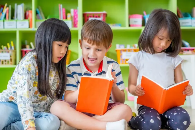 three children are reading books